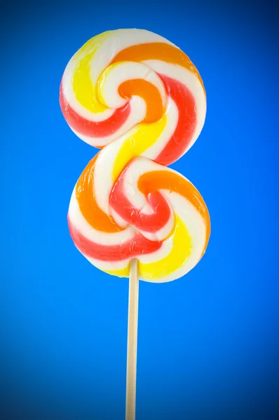 Kleurrijke lollipop tegen de kleurrijke achtergrond — Stockfoto