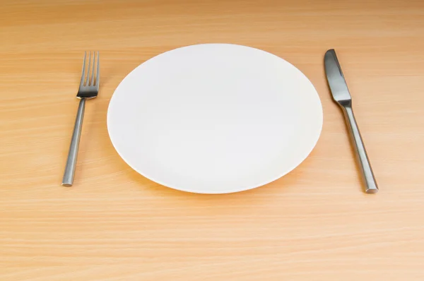 Plaat met keukengerei op houten tafel — Stockfoto