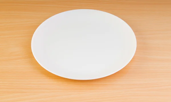 Пустая тарелка на деревянном столе — стоковое фото