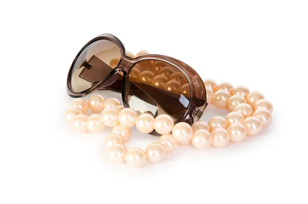 Жемчужное ожерелье и солнечные очки на белом фоне — стоковое фото