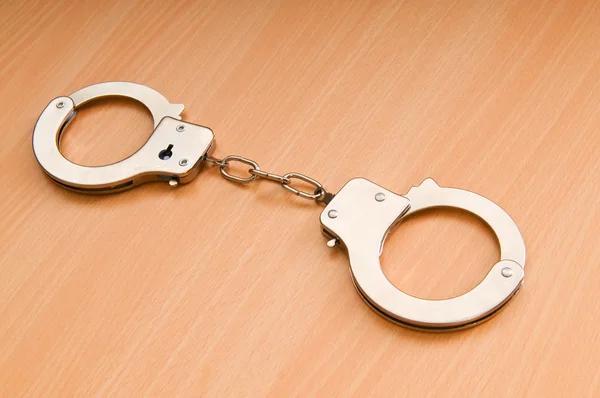 Metal handcuffs on the wooden background — Stock Photo, Image