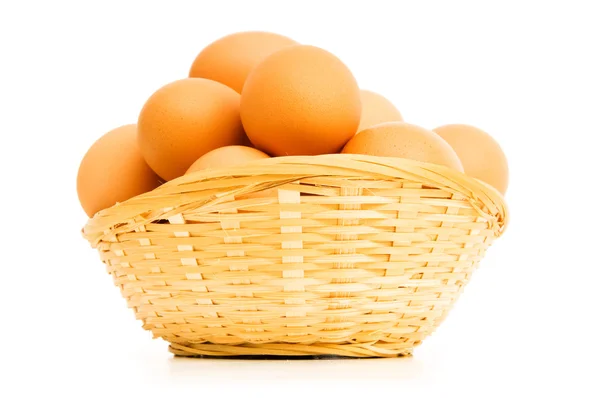Коричневые яйца в корзине на белом — стоковое фото