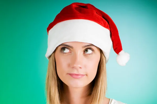 Ragazza con cappello di Babbo Natale contro sfondo sfumato — Foto Stock