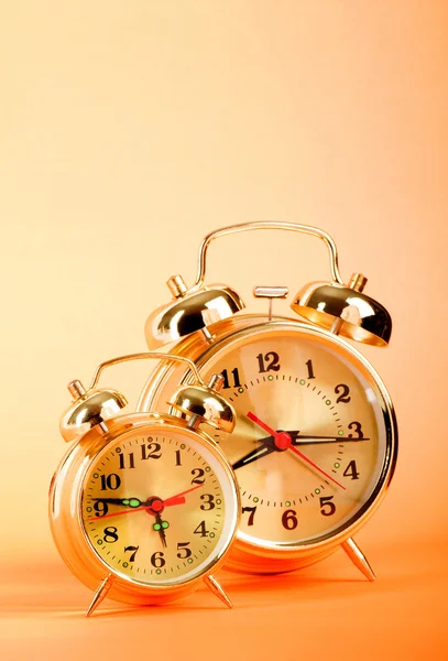 Time concept - alarm clock against colorful background Stock Picture