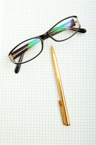 Ручки та окуляри на сторінці — стокове фото