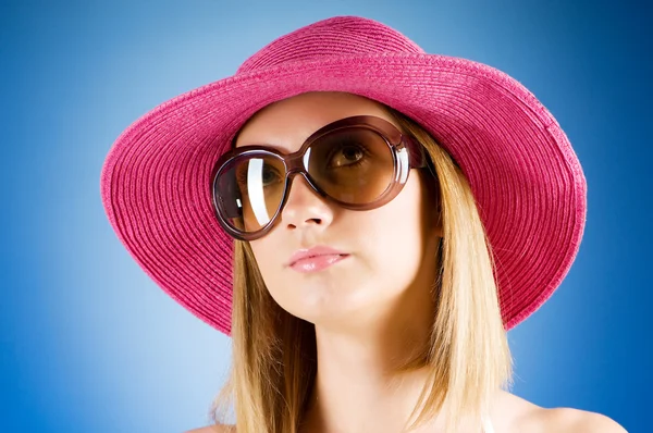 Молодая девушка в пляжной шляпе на фоне градиента — стоковое фото