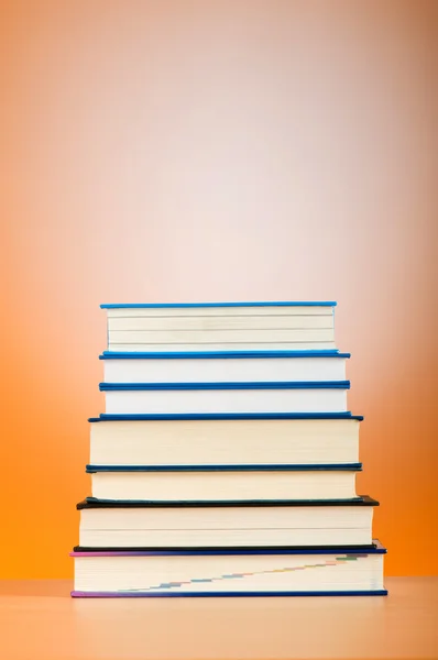 Stapel tekstboeken tegen achtergrond met kleurovergang — Stockfoto