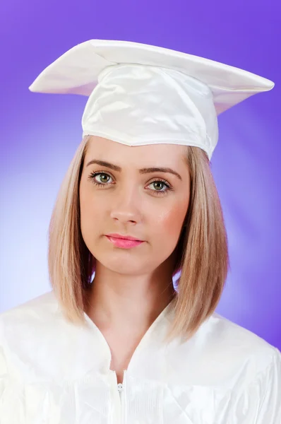 Glad graduate mot färgstarka bakgrund — Stockfoto