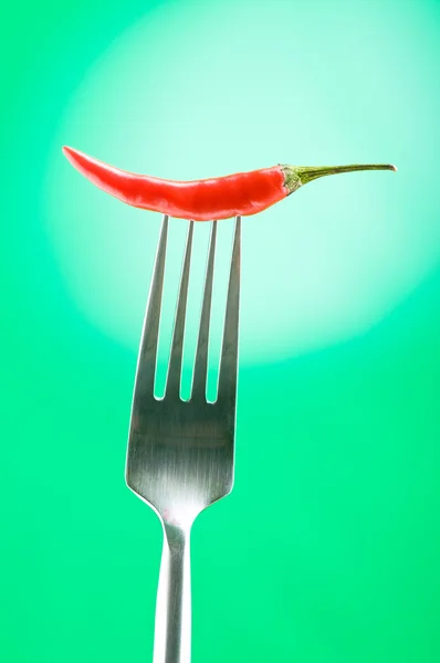 Paprika auf der Gabel vor farbigem Hintergrund — Stockfoto