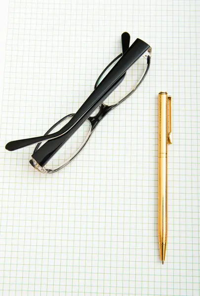 Pen en oog glazen op de pagina — Stockfoto