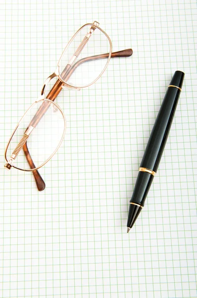 Penna och eye glasögon på sidan — Stockfoto