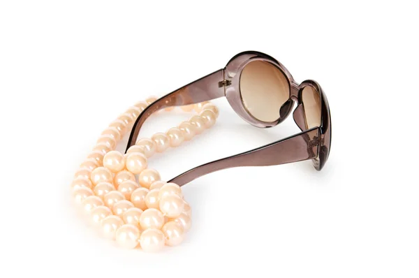 Жемчужное ожерелье и солнечные очки на белом фоне — стоковое фото