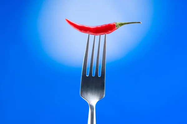 Paprika auf der Gabel vor farbigem Hintergrund — Stockfoto