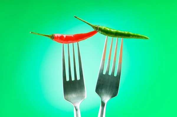 Hot pepper on the fork against colour background — Stock Photo, Image