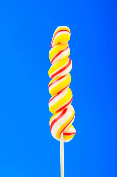 Kleurrijke lollipop tegen de kleurrijke achtergrond — Stockfoto