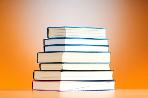 Pila de libros de texto contra el fondo de gradiente — Foto de Stock