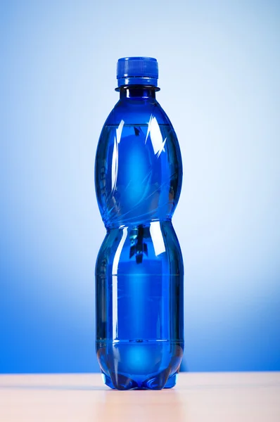 Flasche Wasser vor buntem Hintergrund — Stockfoto