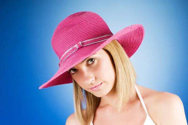 Молодая девушка в пляжной шляпе на фоне градиента — стоковое фото