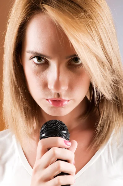 Mädchen singt mit Mikrofon gegen Gradientenhintergrund — Stockfoto