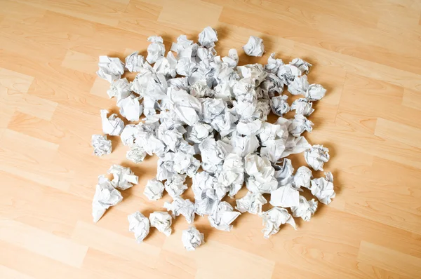 Veel vuilnis papier op de houten vloer — Stockfoto