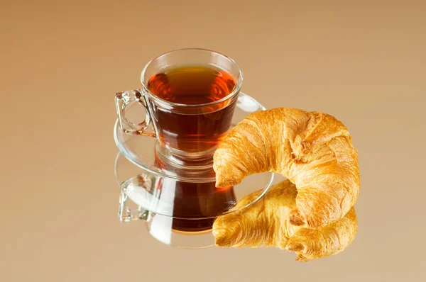 Tea and croissants on the reflective background — Stock Photo, Image
