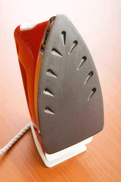 Modern electric iron on the wooden background — Stock Photo, Image
