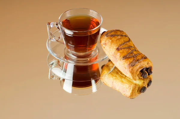 Te och croissanter på reflekterande bakgrund — Stockfoto