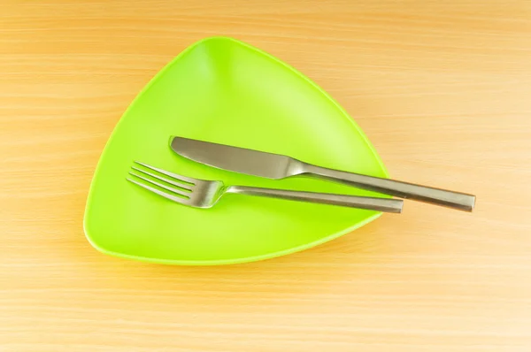 Placa com utensílios sobre mesa de madeira — Fotografia de Stock