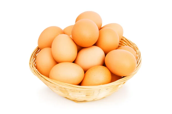 Коричневые яйца в корзине на белом — стоковое фото