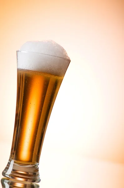 カラフルなグラデーションの背景に対してビールグラス — ストック写真