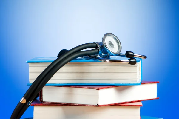 Books and stethoscope against the gradient background — Stock Photo, Image