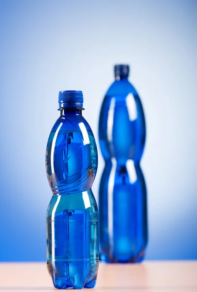 Flasche Wasser vor buntem Hintergrund — Stockfoto