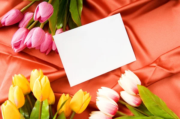 Envelope and flowers on the satin background Stock Image