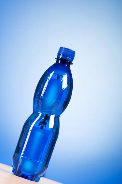 カラフルなグラデーションの背景に対する水のボトル — ストック写真