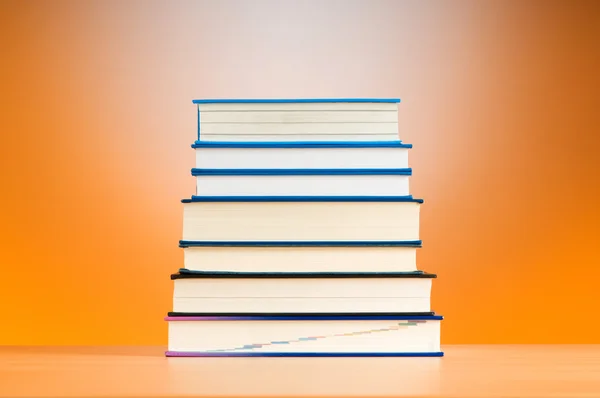 Pila de libros de texto contra el fondo de gradiente — Foto de Stock
