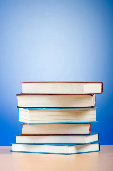 Stack of text books against gradient background — Stock Photo, Image