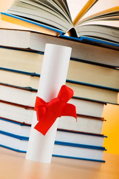 Diploma y pila de libros sobre el fondo —  Fotos de Stock