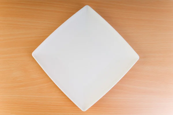 Leerer Teller auf dem Holztisch — Stockfoto