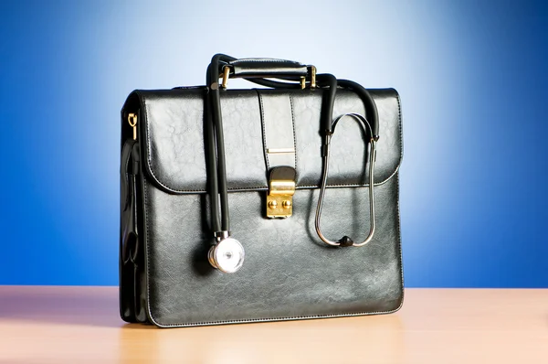 Arztkoffer mit Stethoskop vor buntem Hintergrund — Stockfoto