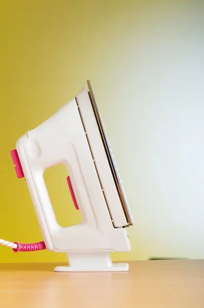 Modern electric iron against the colorful background — Stock Photo, Image