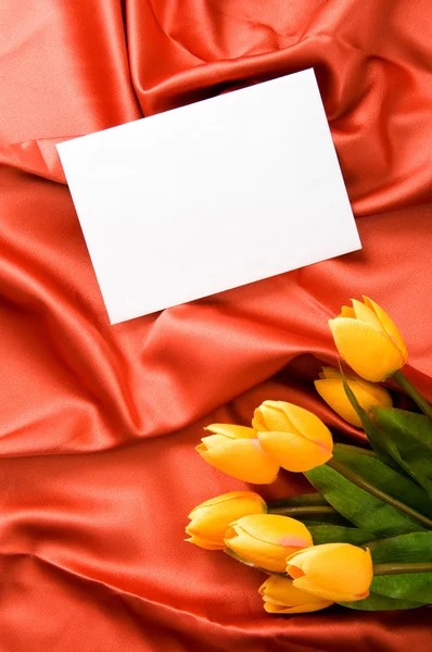 Enveloppe et fleurs sur fond satiné — Photo