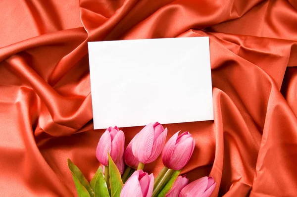 Enveloppe et fleurs sur fond satiné — Photo