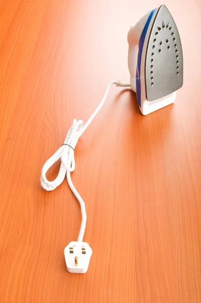 Modern electric iron on the wooden background — Stock Photo, Image