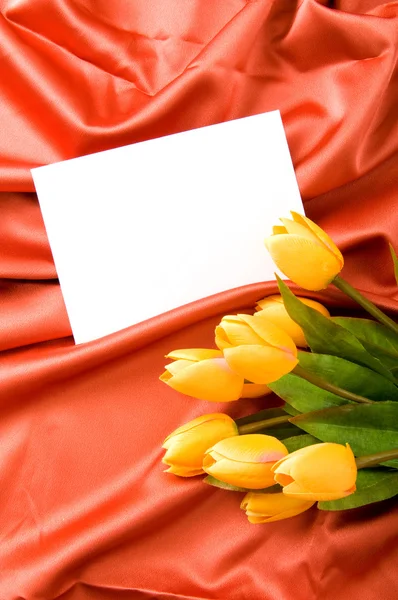 サテンの背景の封筒と花 — ストック写真