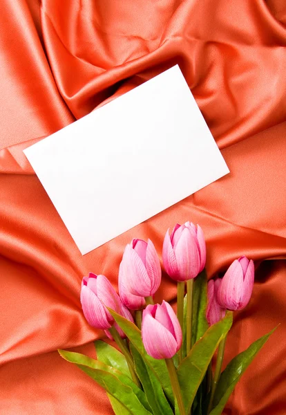 Kuvert och blommor på satin bakgrund — Stockfoto