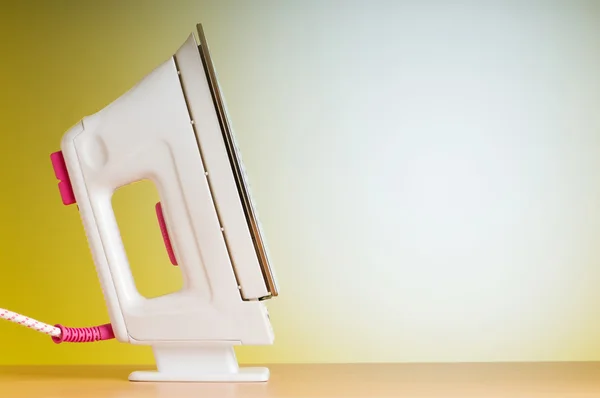 Modern electric iron against the colorful background — Stock Photo, Image
