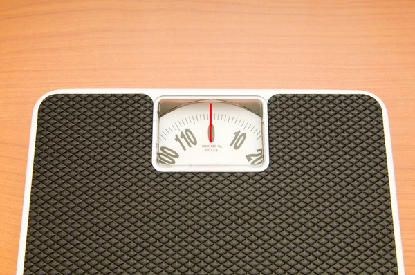 Концепция диеты с весами на деревянном полу — стоковое фото