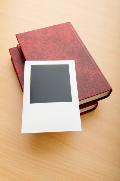 Livros e fotos em branco na mesa de madeira — Fotografia de Stock