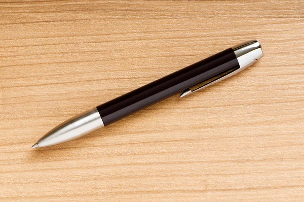 Psaní stříbrné pero na dřevěné pozadí — Stock fotografie