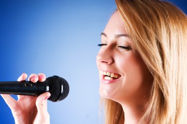 mikrofon degrade arka plan ile şarkı söyleyen kız